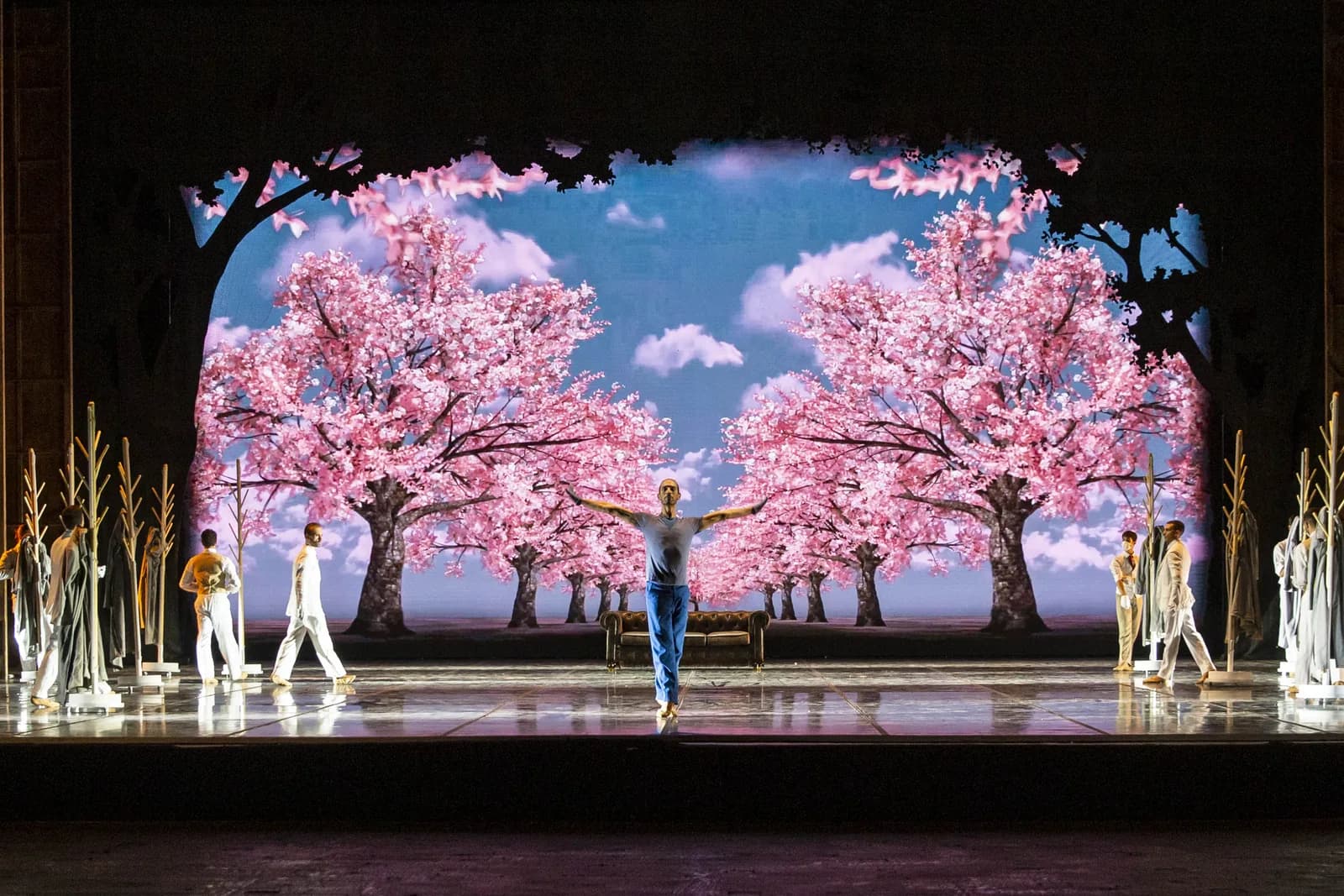 Cerisiers en fleurs peints sur un ciel bleu, un danseur seul au centre