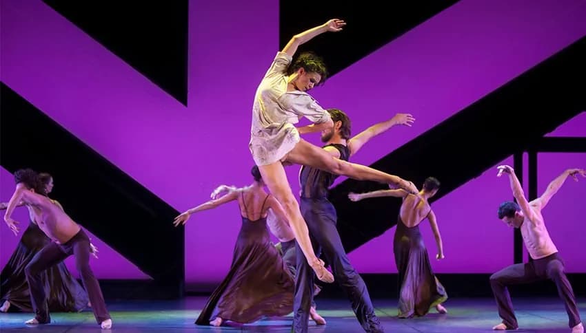 Danseuse portée au-dessus d'un groupe devant un fond magenta