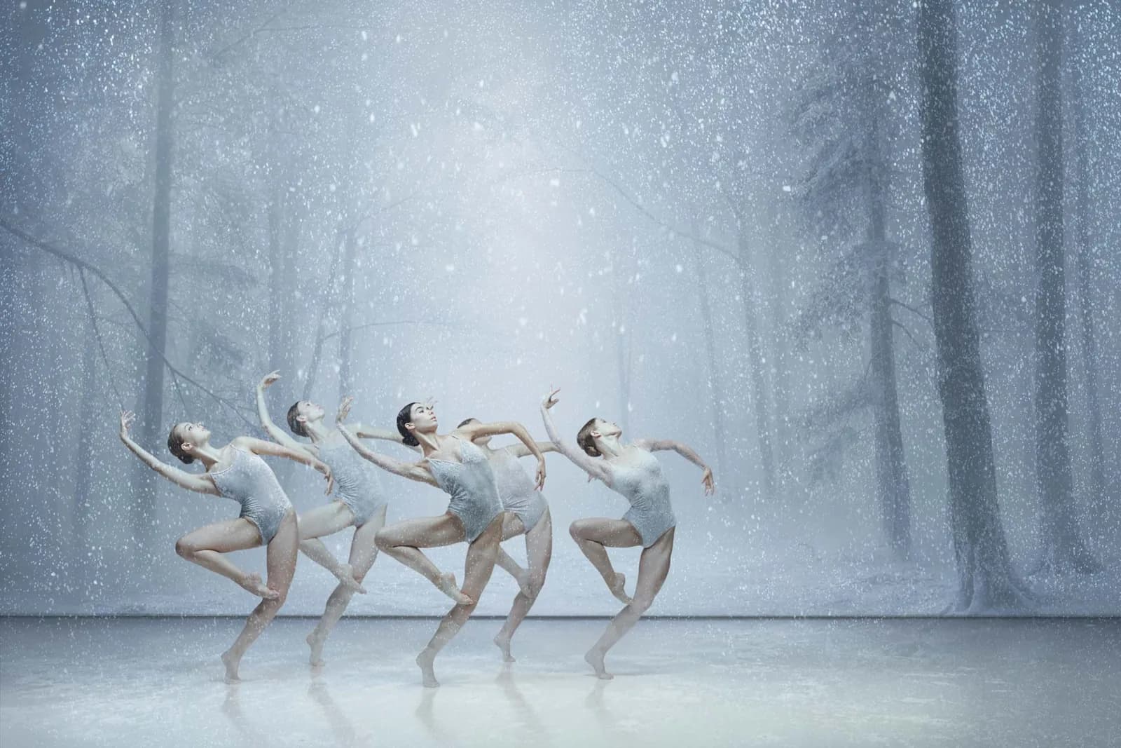 L'hiver : les danseurs sous une lumière bleu glacé et la neige