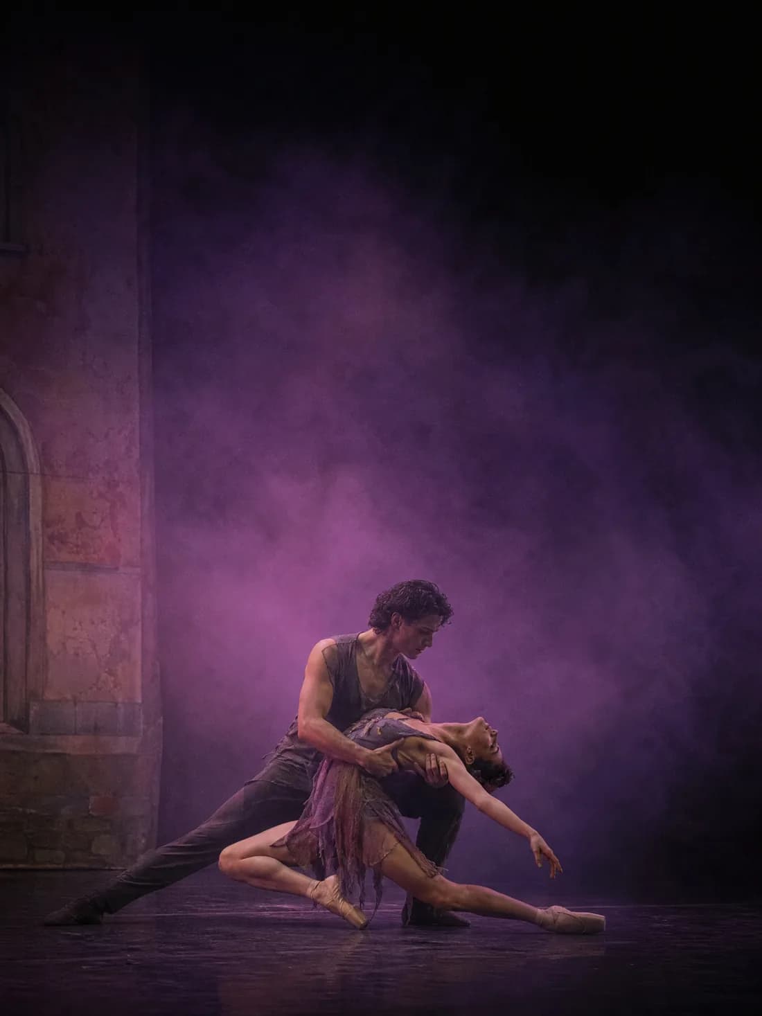 Deux danseurs dans un porté bas, contre-jour violet et fumée épaisse, ancien décor peint en fond