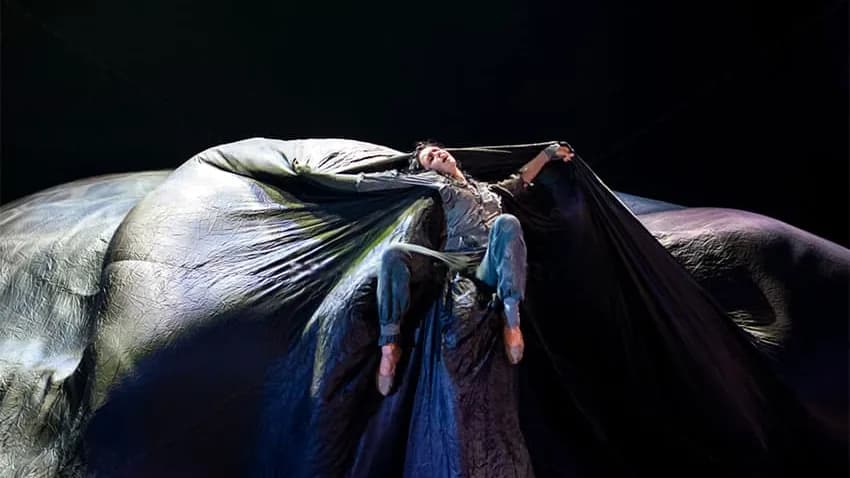 Danseuse suspendue dans une immense draperie grise